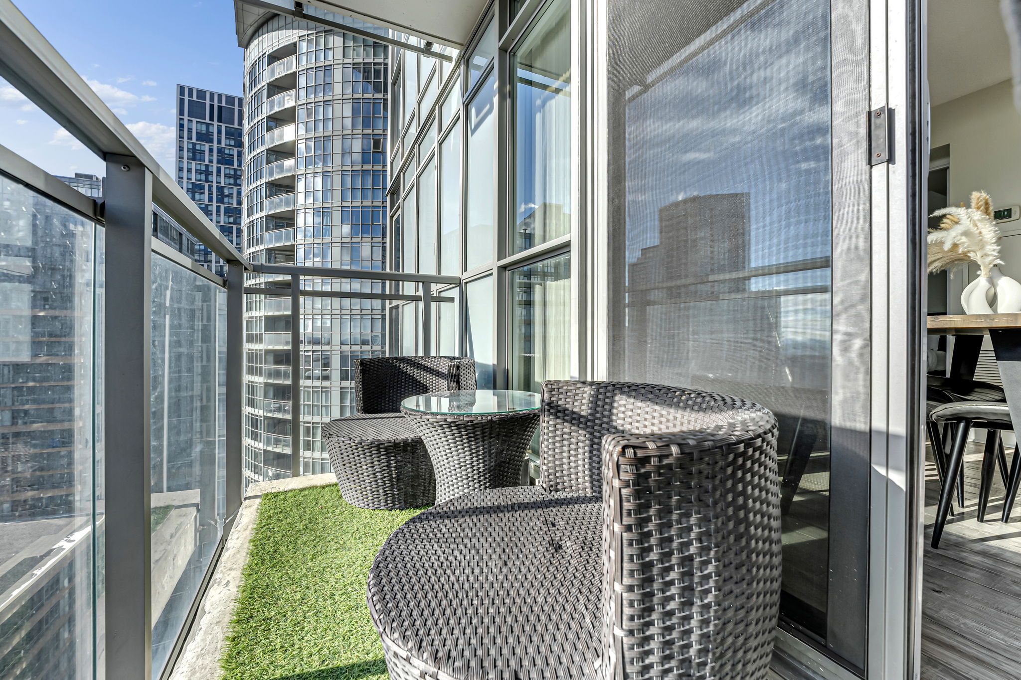Balcony with turf and wicker seating overlooking downtown Toronto at 15 Iceboat Terrace