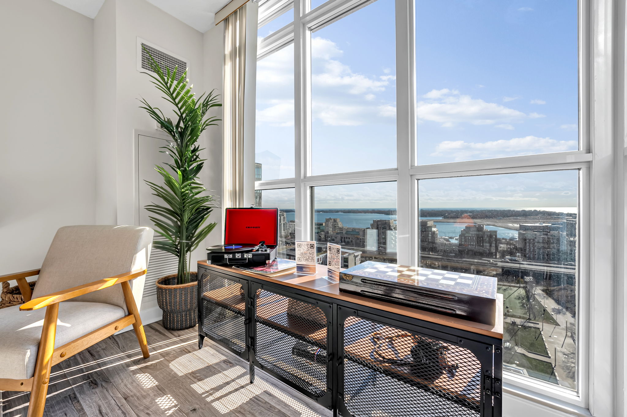 Sunlit den with floor-to-ceiling windows and lake views in a Certus-managed rental at 15 Iceboat Terrace
