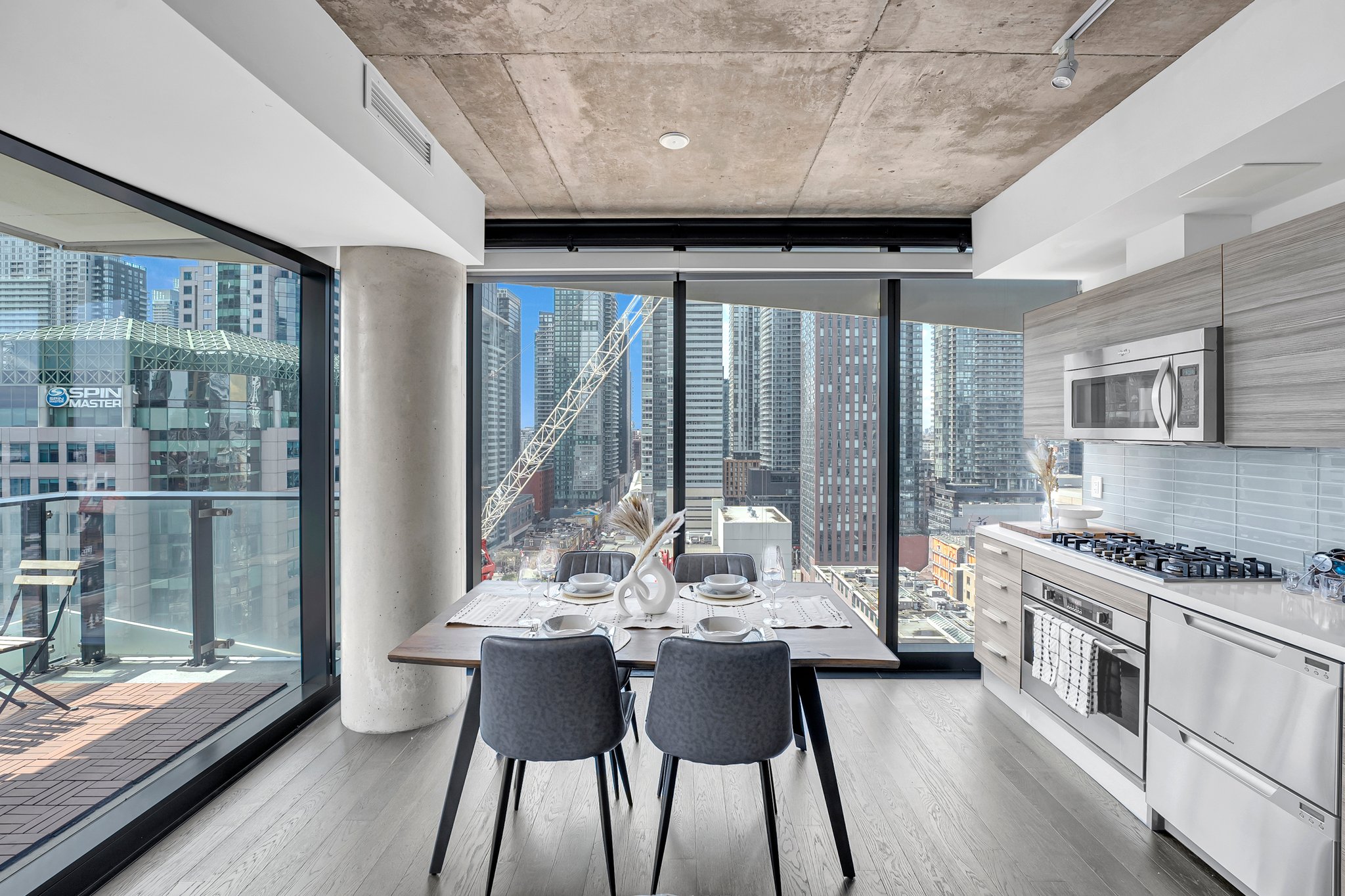 Dining area and kitchen with floor-to-ceiling downtown views in a Certus-managed rental at 224 King St W