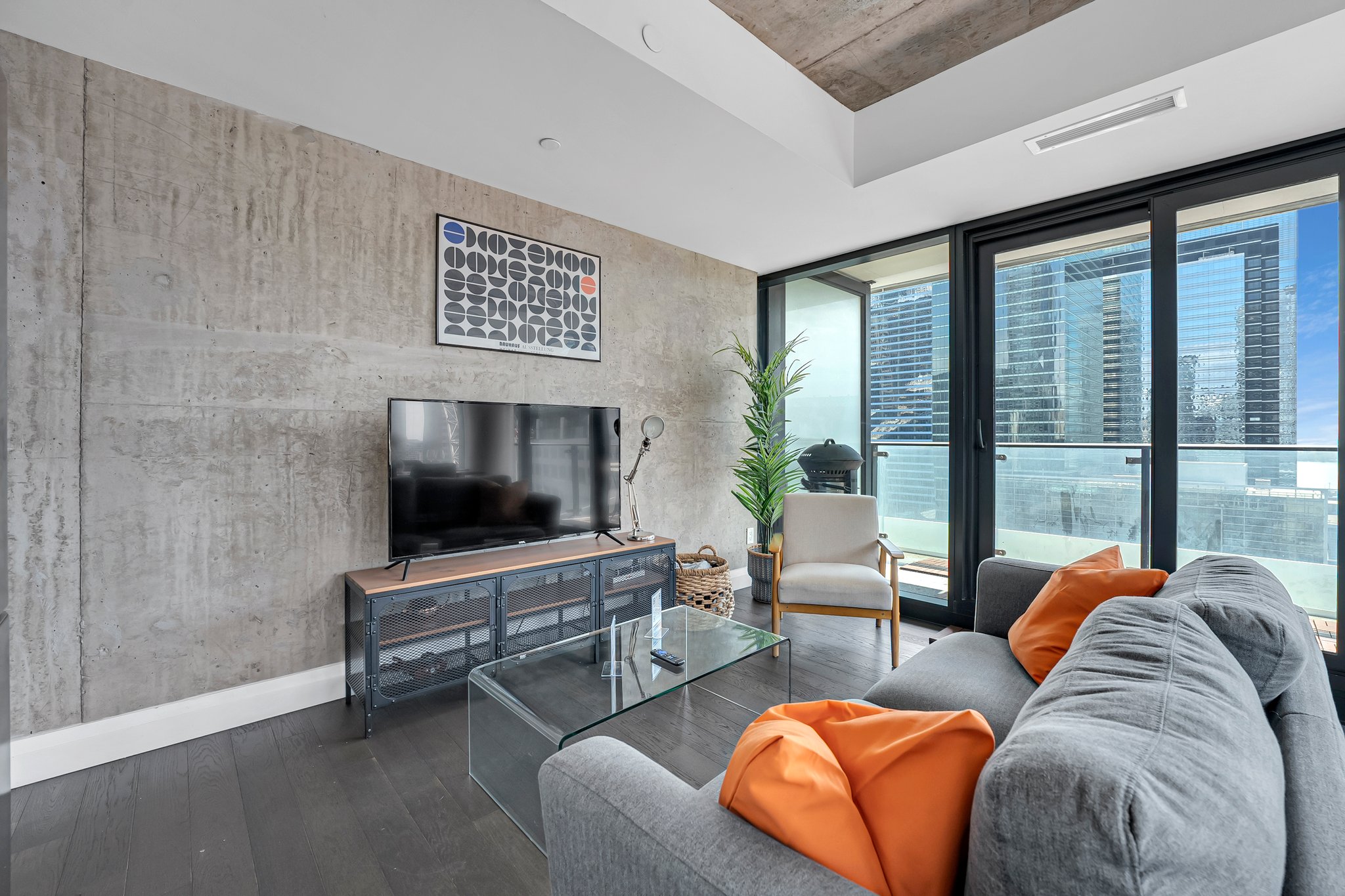 Loft-style living room with exposed concrete ceiling and skyline views at 224 King St W, Theatre Park, Toronto